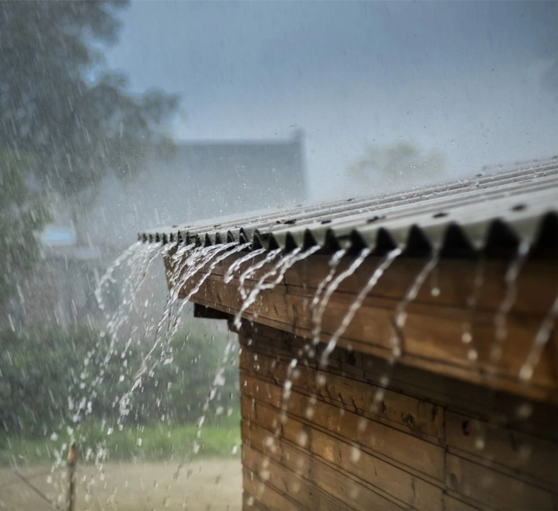 A rain shower is pouring on the roof of a house.